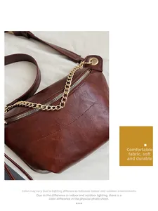 Detail of dark brown leather texture with golden metal zipper and chain strap