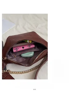 Top view of brown leather bag interior with zipper pocket and daily essentials