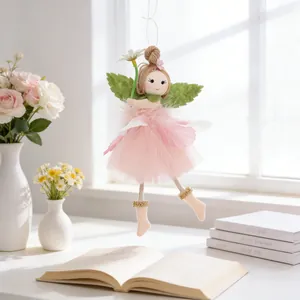Detail of pink tulle fairy doll ornament with flower crown hanging on desk