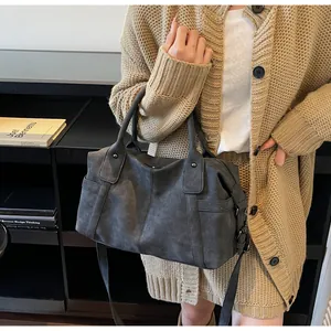 Detail of dark grey travel tote bag featuring matte texture and adjustable strap