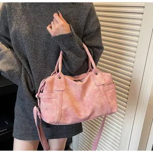 Close-up of pink large-capacity shoulder bag with textured leather and metal rivets