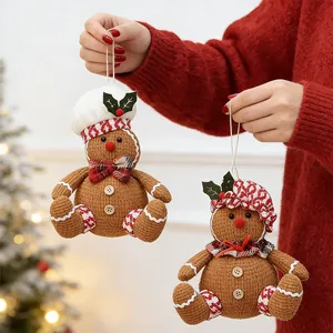 Close-up of gingerbread chef plush ornaments held against a festive Christmas tree background