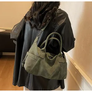Detail of vintage green high-capacity shoulder bag with textured finish and adjustable strap