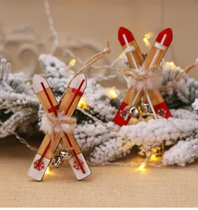 Detail view of a wooden sled Christmas ornament with red tips, bells, and faux fur ball