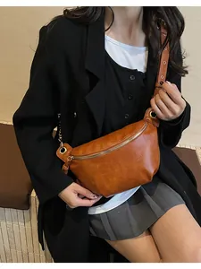 Close-up of vintage brown PU leather crossbody bag featuring metal zipper and wide strap