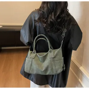 Deep green frosted leather travel bag shown on shoulder for size reference and style