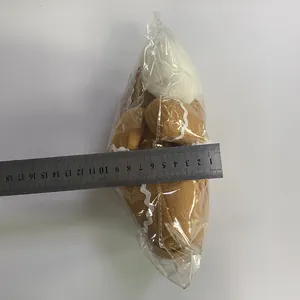 Detail showing plush gingerbread man doll with wavy trim measured with a steel ruler