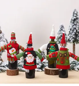 Detail of four festive knitted Christmas wine bottle covers with holiday themed patterns