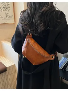 Retro brown faux leather moon bag with gold zipper and stylish tassel on model's back
