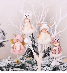 Detail of four plush Christmas angel ornaments hanging on a white festive branch