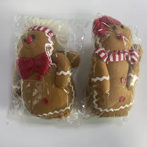 Detail of Christmas gingerbread plush dolls with chef hats and red buttons in packaging