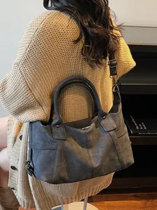 Large dark grey suede texture tote bag with crossbody strap for women in travel scenario