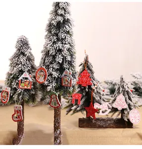 Detailed view of handcrafted wooden Christmas ornaments hanging on a snowy holiday tree