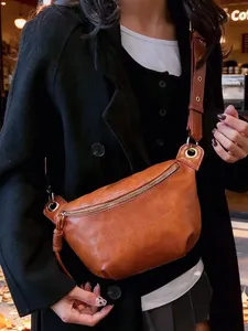 Brown vintage motorcycle style saddle bag with adjustable wide strap and gold zipper