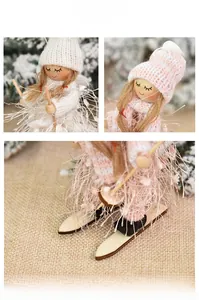 Close-up of knit hats and faux fur details on pink and white skiing Christmas dolls