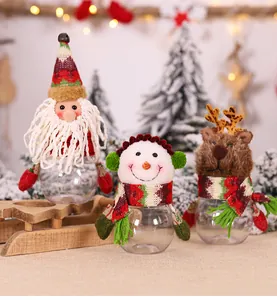 Close-up of Christmas candy jars with Santa, snowman and reindeer plush heads