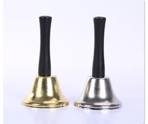 Dettaglio di campanelli a mano in metallo oro e argento con manici neri su sfondo bianco