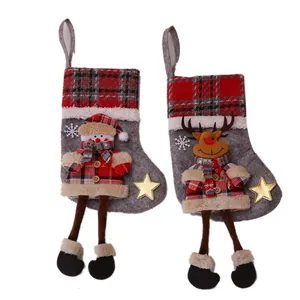 Two Christmas stockings with snowman and reindeer plaid patterns and long dangling legs