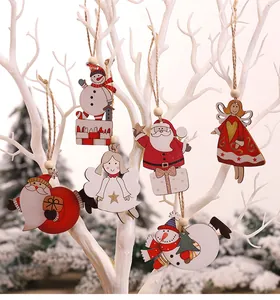 Detail van houten kersthangers met de Kerstman en een sneeuwpop hangend aan een boom