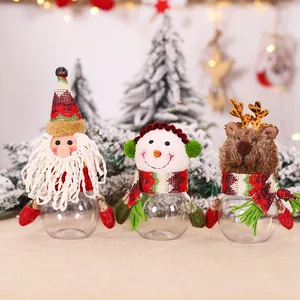 Three Christmas character candy jars with Santa, Snowman, and Reindeer in festive setting