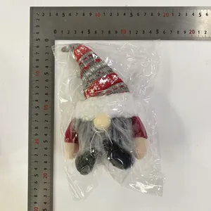 Detail shot of Christmas gnome ornament with striped hat beside a ruler for size reference