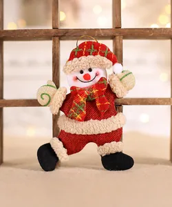 Detailed view of burlap snowman ornament with red and green plaid scarf and golden string