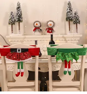 Dettaglio coprisedia natalizi con design a gonna di Babbo Natale ed elfo con gambe lunghe