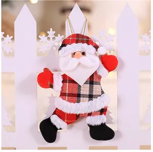 Detail of Santa Claus ornament with plaid fabric and white faux fur trim hanging on fence