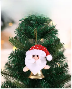 Plush Santa ornament with gold bell hanging on a green Christmas tree branch