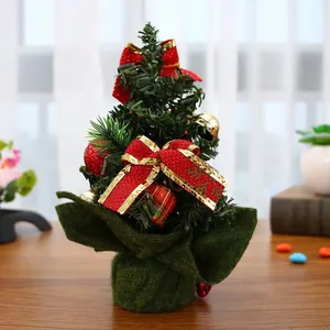 Detalle de mini árbol de Navidad de 20 cm con lazos rojos y cascabeles dorados decorativos