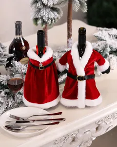 Detalle de fundas navideñas de terciopelo rojo para botellas con piel blanca y hebillas oro