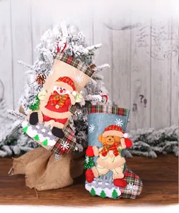 Close-up of burlap Christmas stockings featuring snowman and bear plush embroidery decor