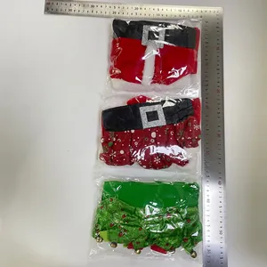 Dettaglio copribottiglie natalizi con cintura di Babbo Natale e campanellini da elfo