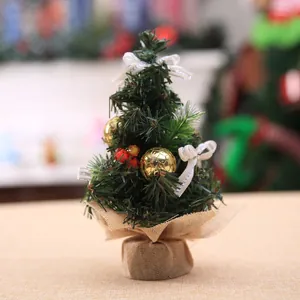 Detalle de mini árbol de Navidad 20cm con adornos dorados y base de tela de arpillera