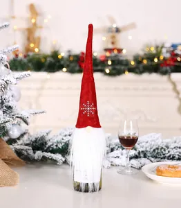 Detail of red plush Christmas gnome wine bottle cover with snowflake embroidery and long beard