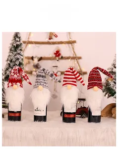 Detail of four knit Christmas gnome wine bottle covers with snowflakes and faux fur beards