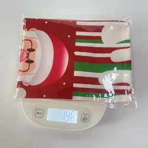 Weight measurement of Santa Claus print wine bottle cover in packaging showing 19.6g