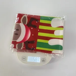 Detailed view of Christmas wine bottle cover packaging weighing 58.7g on a digital scale