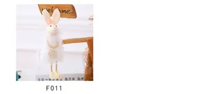 Dettaglio di coniglietto pasquale di peluche con fiocco rosa, fiore e gambe in corda