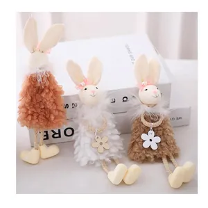 Dettaglio di tre coniglietti pasquali di peluche con fiocchi e fiori per decorazioni
