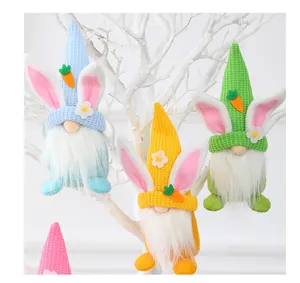 Three Easter gnomes with rabbit ears and carrots hanging on white decorative tree branches