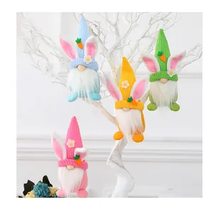 Detailed view of colorful knitted Easter gnomes with rabbit ears hanging on white branches