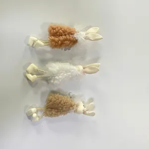 Dettaglio di ornamenti pasquali a forma di coniglio in morbida lana marrone e bianca