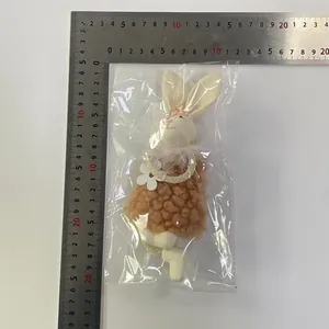 Dettaglio del ciondolo a forma di coniglietto pasquale in peluche con righello metallico