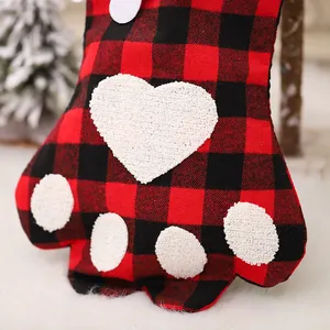Red and black buffalo plaid Christmas stocking in dog paw shape with heart detail