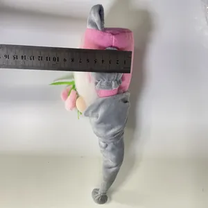 Macro view showing the gnome plush toy width measurement with a steel ruler