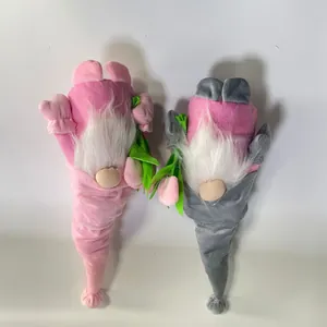 Close-up of two plush Mother's Day gnomes with long white beards and pink tulips