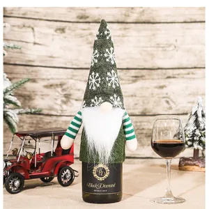Detailed view of gnome wine bottle cover with green knit hat and white snowflake pattern