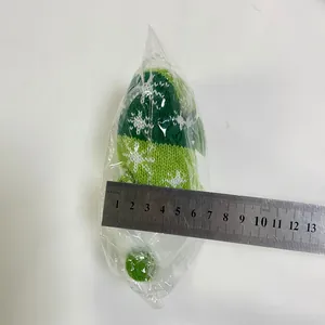 Dettaglio di uno gnomo natalizio in maglia verde con motivi a fiocchi di neve, circa 7cm