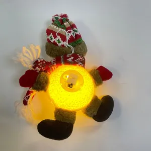 Detail of illuminated plush Christmas ornament showing battery compartment and LED switch